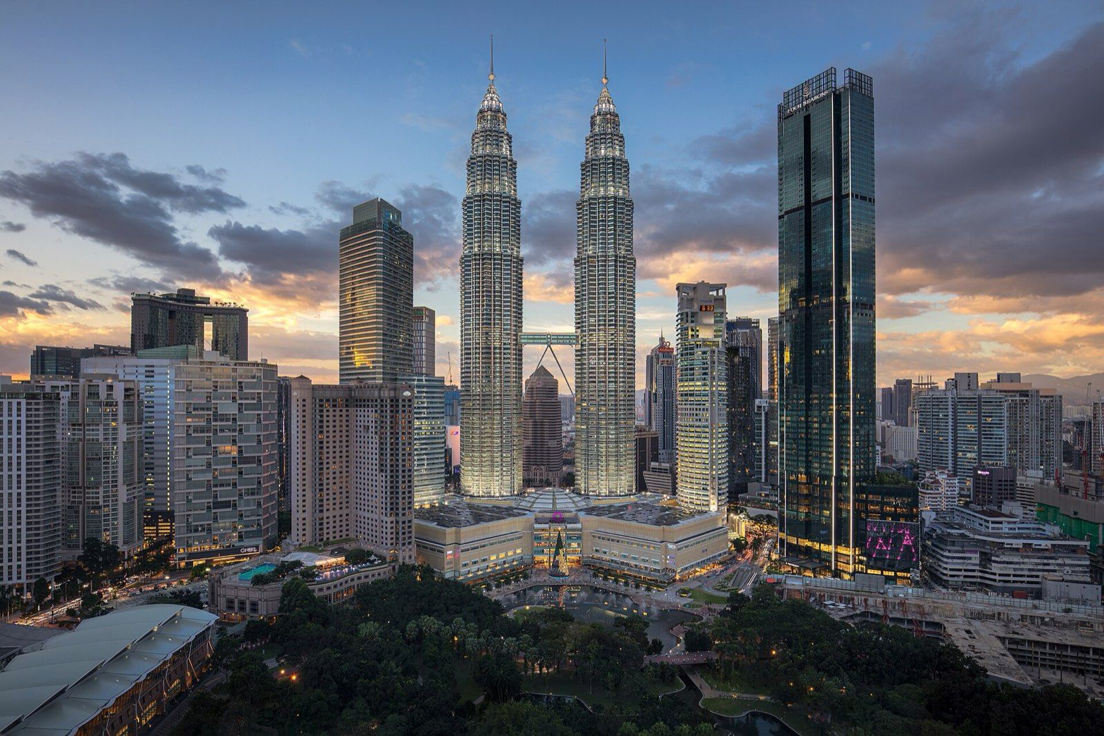 Kuala Lumpur City Centre at dusk, with the Petronas Twin Towers lit above KLCC Park