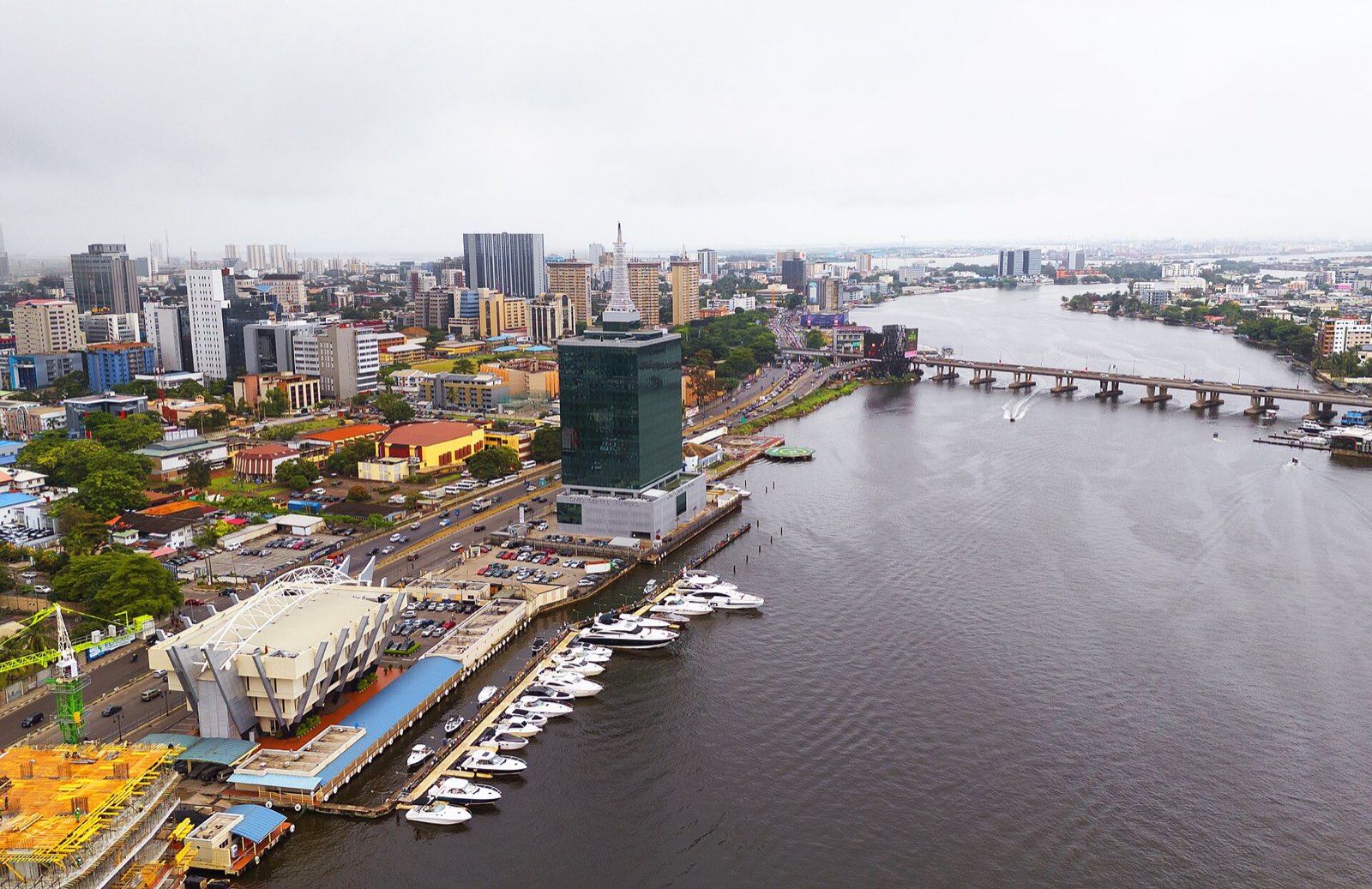 Aerial view of Victoria Island, Lagos: office towers and a marina along Five Cowrie Creek, with a road bridge crossing the water